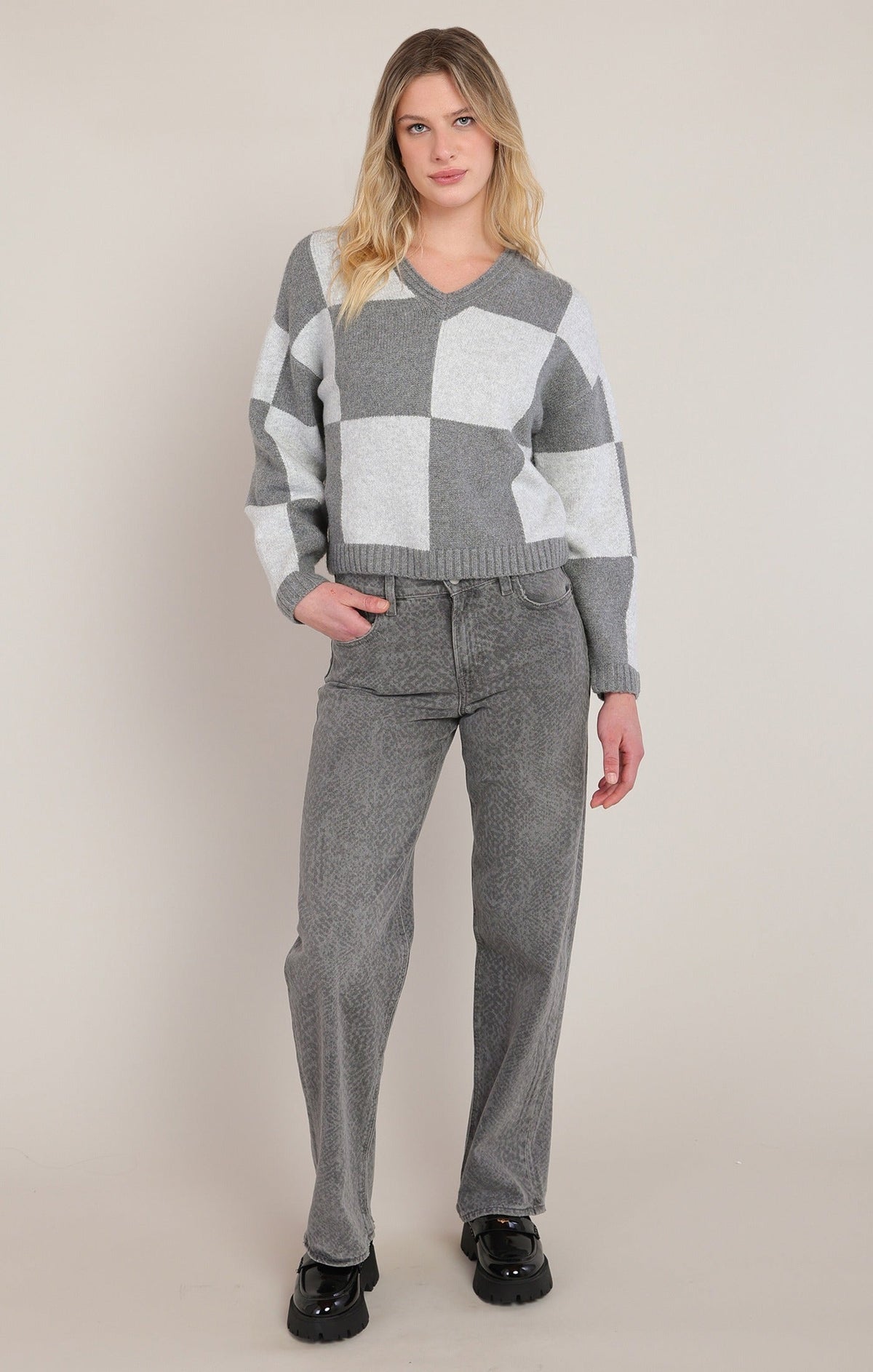 Dex heather grey colorblock v-neck sweater with large checkerboard pattern, styled with grey jeans