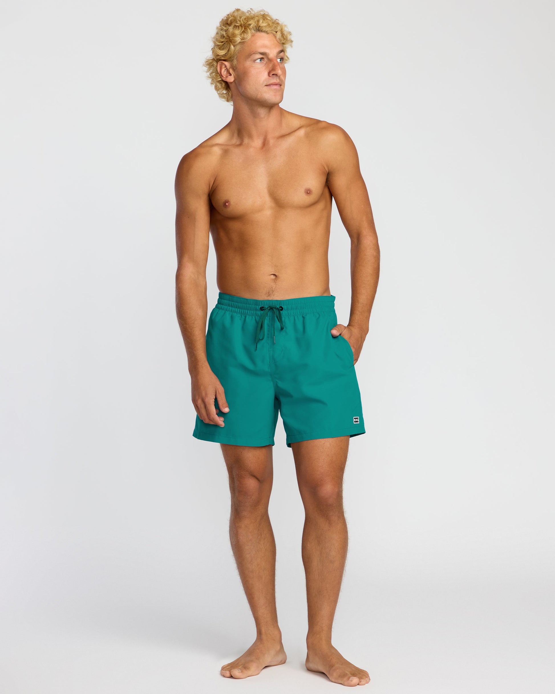 Man wearing Billabong All Day LB swim shorts in tropical teal color