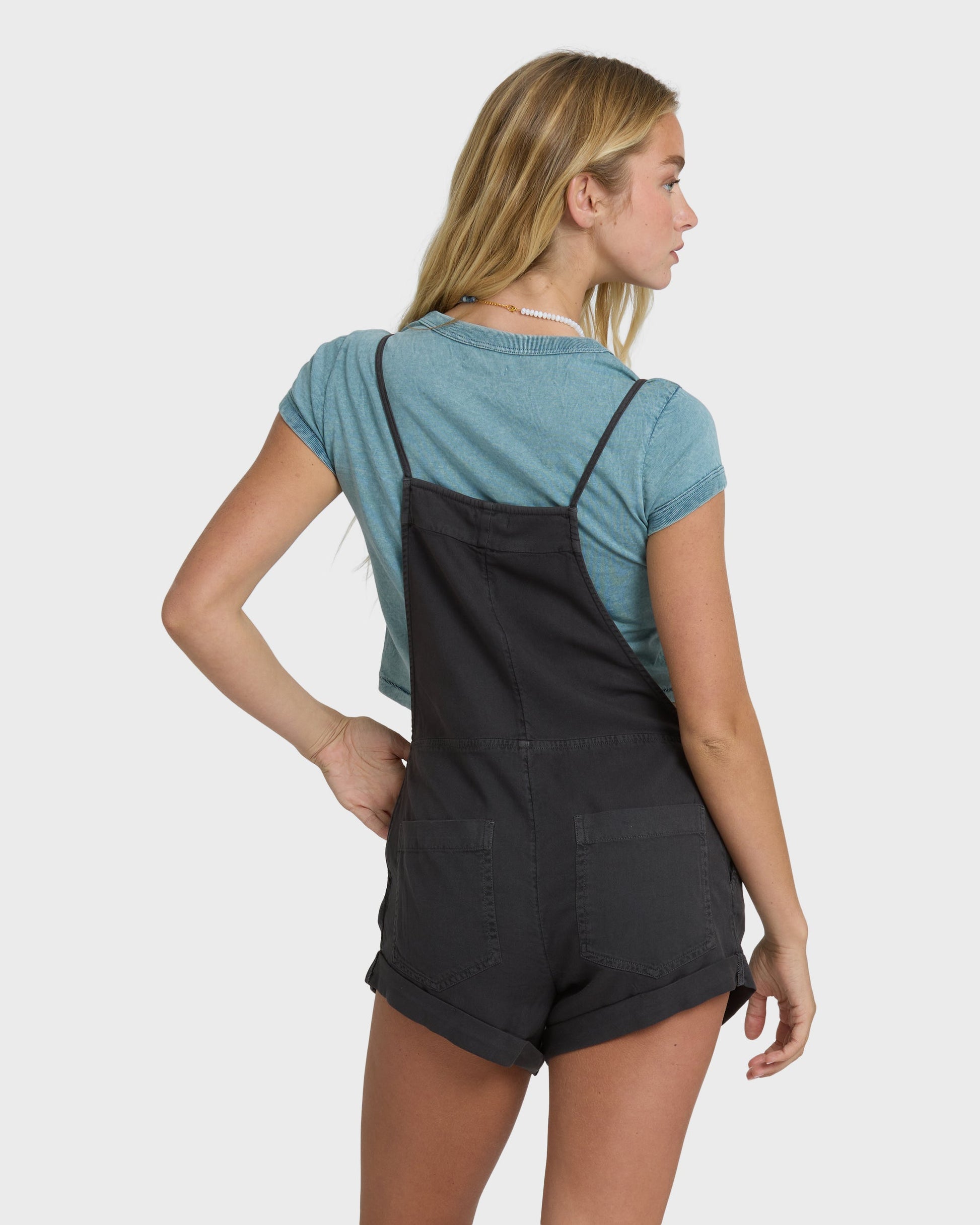 Billabong Wild Pursuit Overall Solid in off-black worn over teal tee, back view