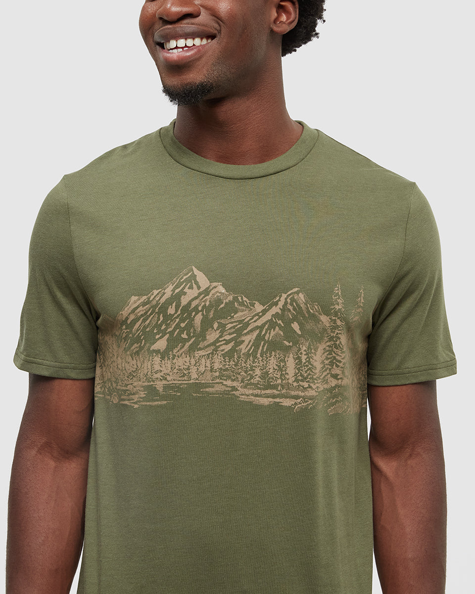 Man wearing olive green t-shirt with mountain landscape graphic print