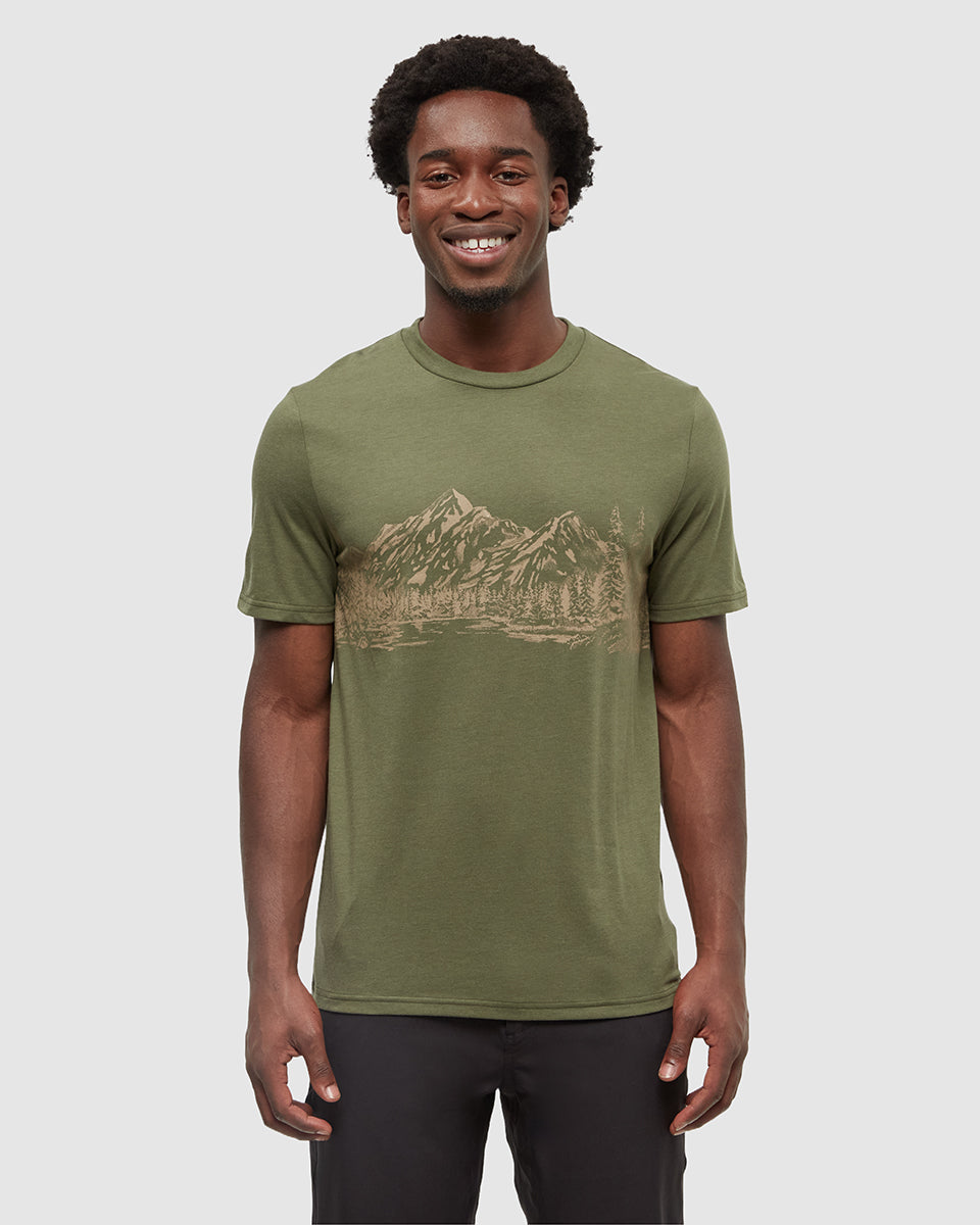 Man wearing olive green Tentree t-shirt with mountain landscape graphic print