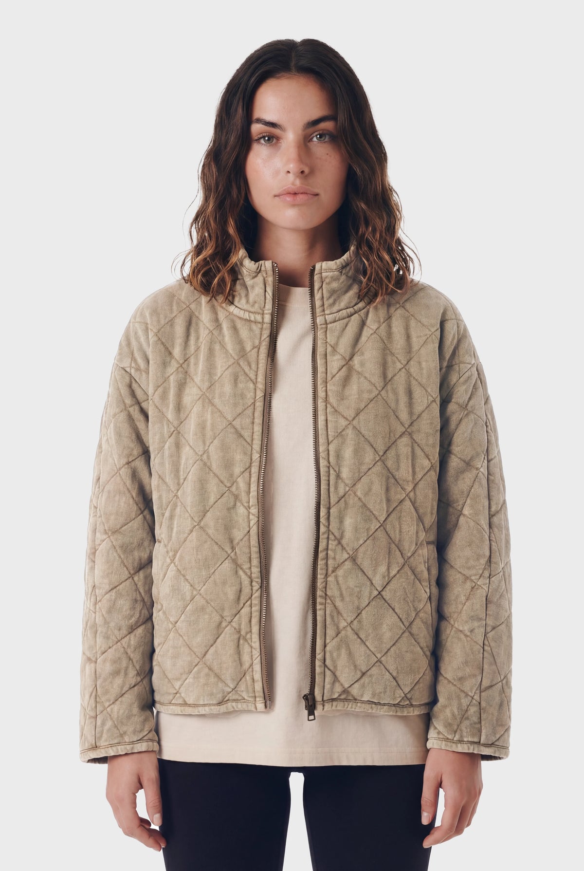 Woman wearing TeamLTD Northway Quilted Jacket in washed khaki with diamond quilting pattern