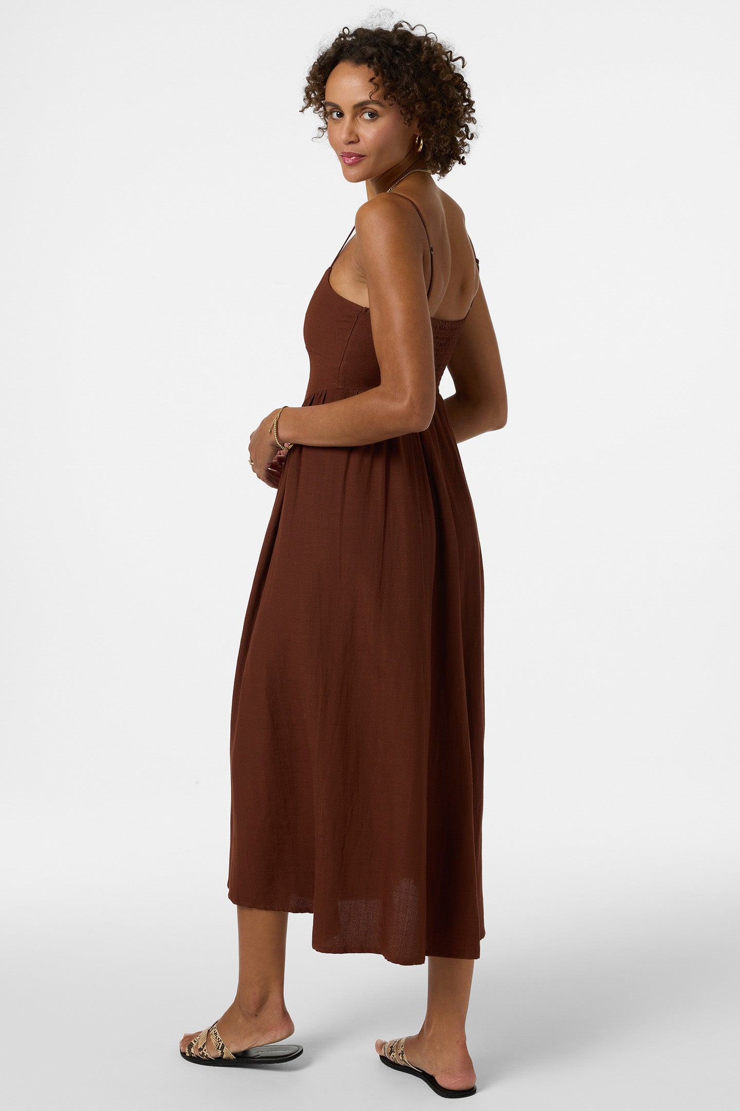 Woman wearing brown midi dress with spaghetti straps and flowing skirt