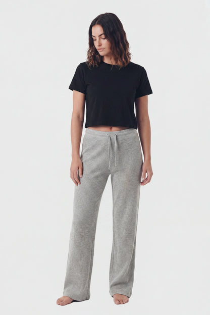 Woman wearing grey waffle knit lounge pants with drawstring waist and black crop top