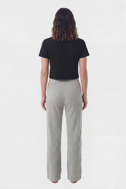 Back view of model wearing grey waffle knit lounge pants with black crop top