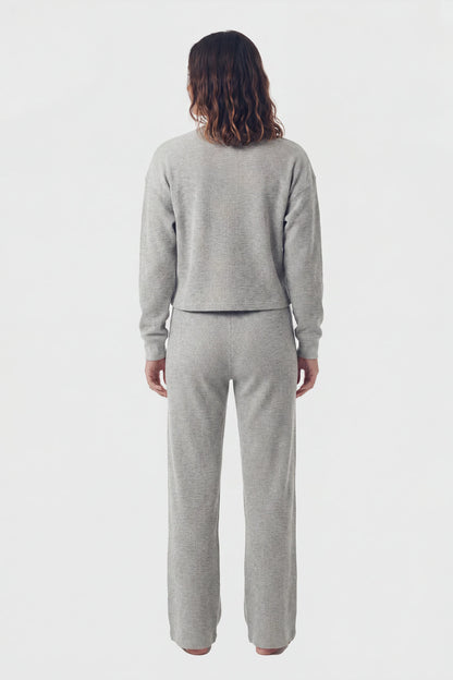 Model wearing grey waffle-knit lounge pants and matching top, back view