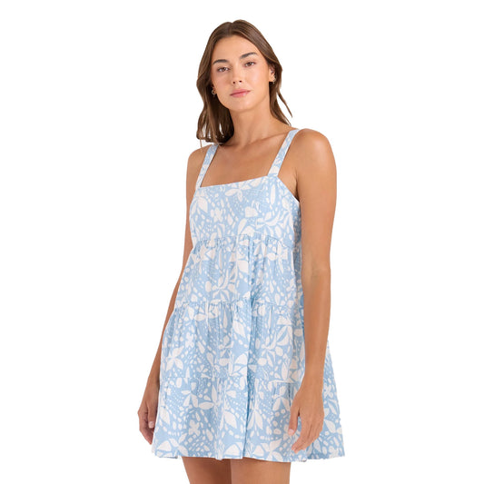 Woman wearing light blue floral print sleeveless tiered mini dress with straps