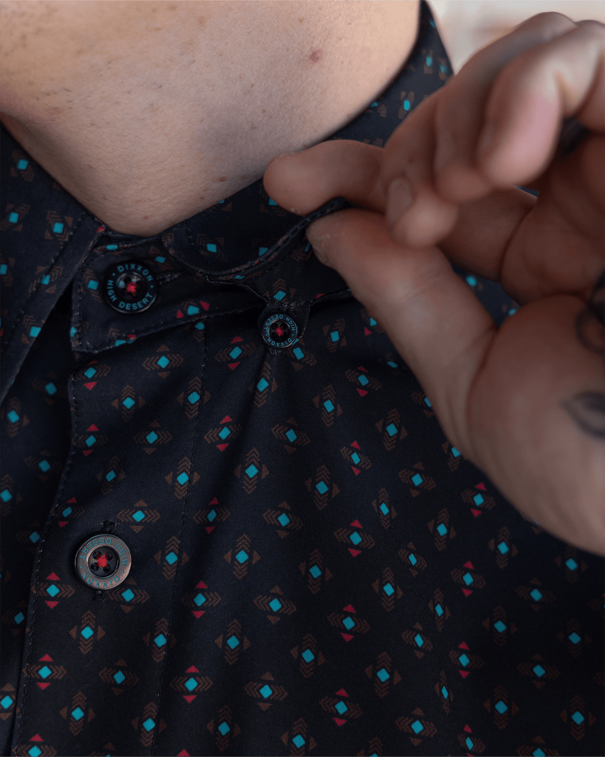 Dixxon High Desert Party Shirt close-up showing branded buttons and geometric pattern on black fabric