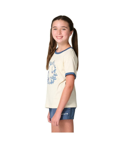 Girl wearing Carhartt Kids cream ringer tee with blue floral C graphic and blue shorts