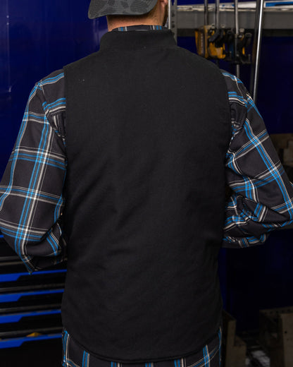 Back view of Dixxon Outlaw Work Vest in black over blue plaid flannel shirt