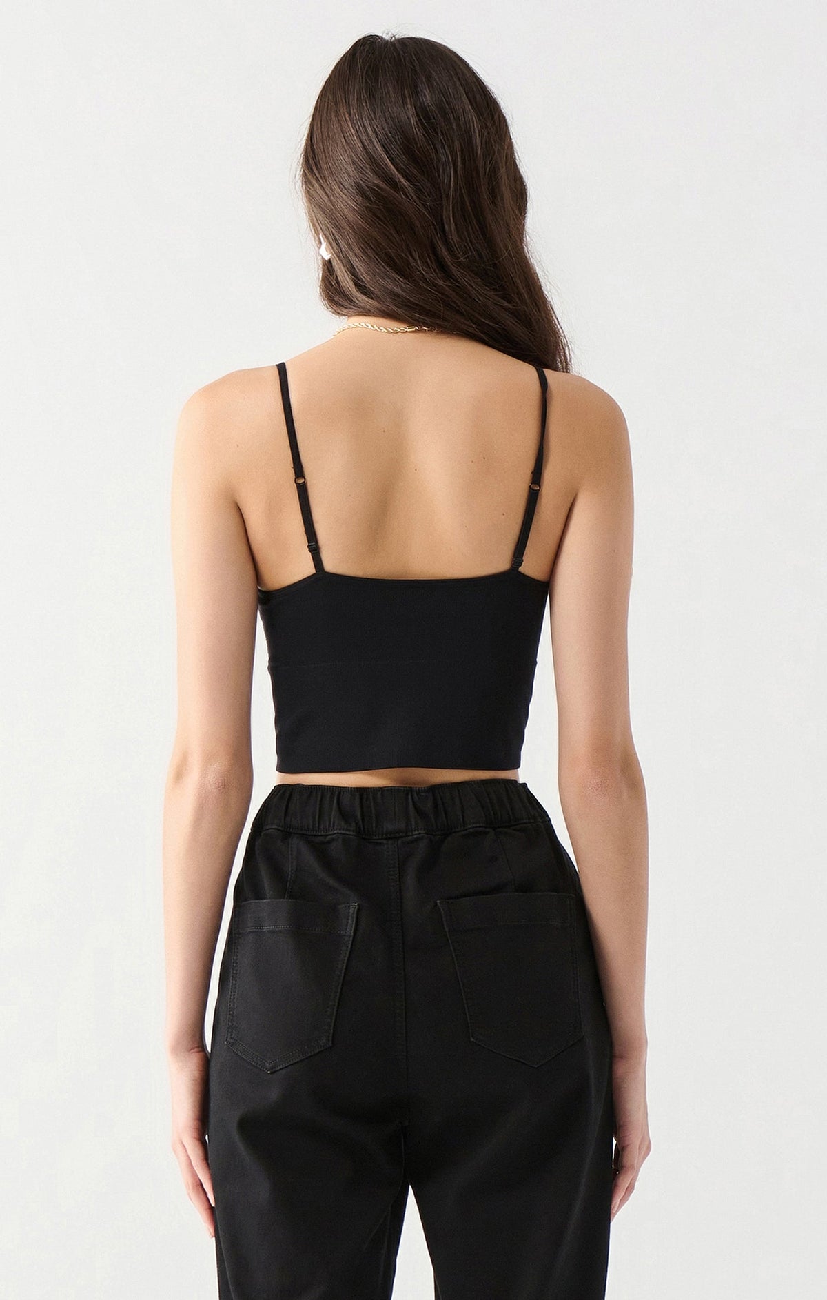 Back view of black seamless spaghetti strap crop bra top on model